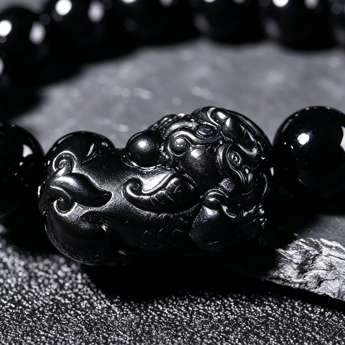 Black obsidian bracelet worn on a man's wrist – WUFORGE